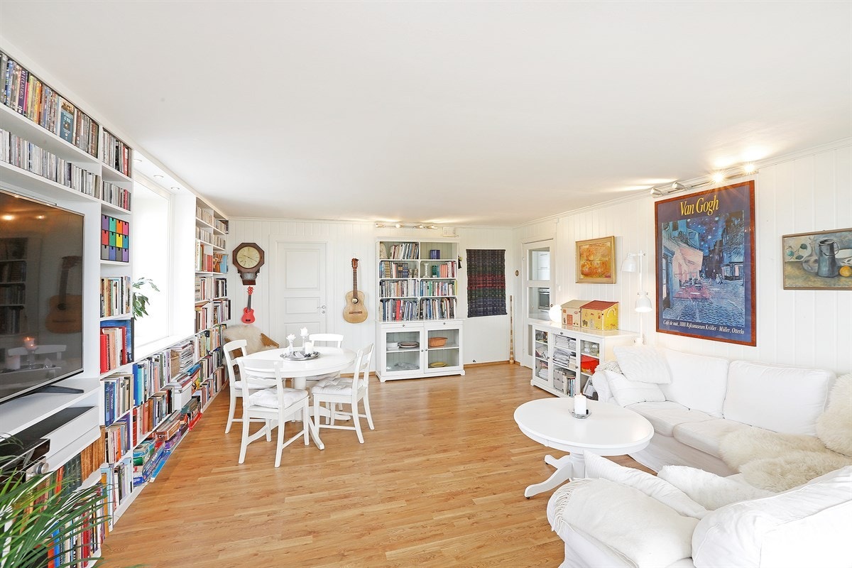 Romslig stue med plass til spisebord. Innredet med stor bokhylle Galleribilde