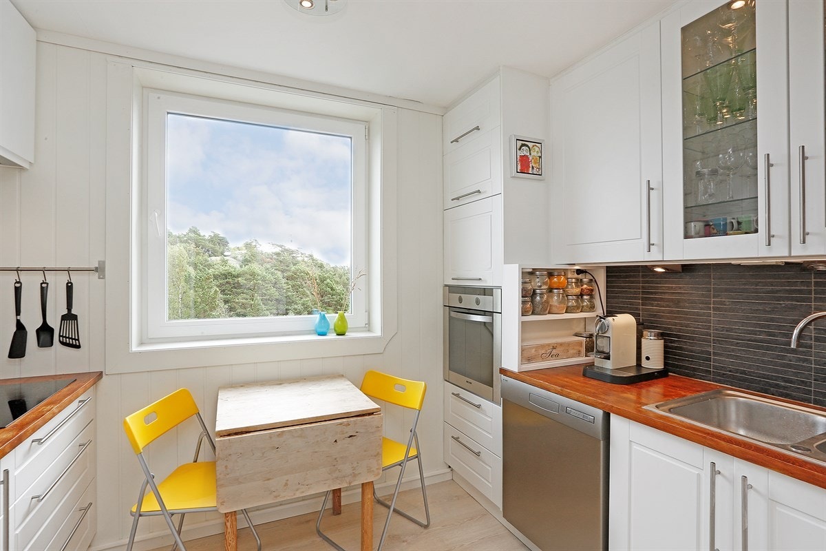 Lyst og delikat kjøkken med integrert hvitevarer Galleribilde