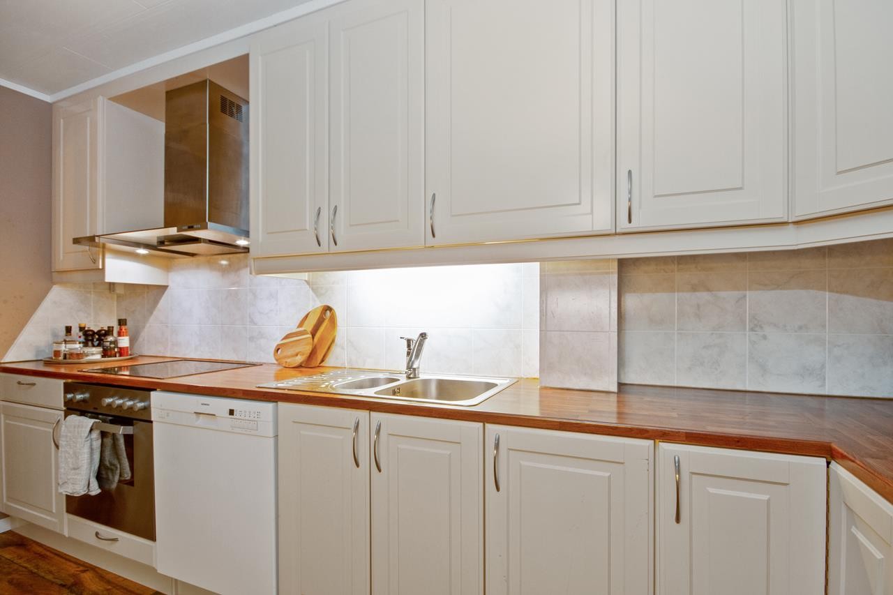 Benkeplaten er i mørk laminat, med en nedfelt dobbel oppvaskkum og god plass for matlaging. Galleribilde