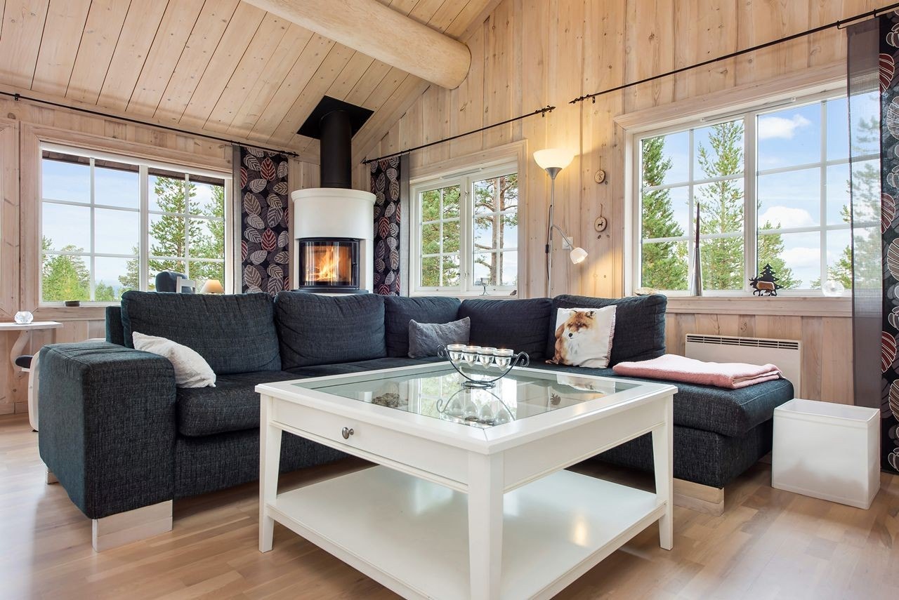 Store vindusflater slipper dagslys og utsikt inn i hytta Galleribilde