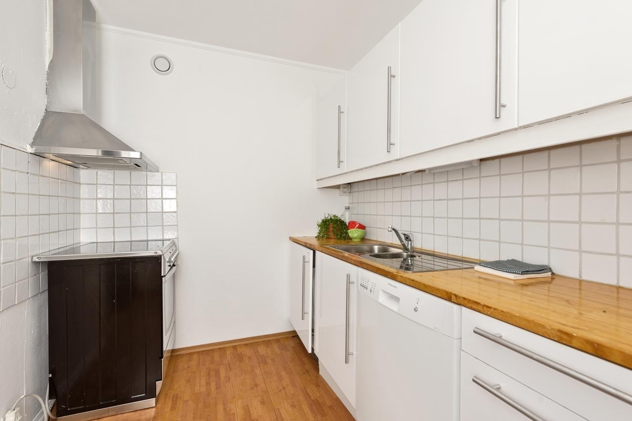 Separat kjøkken med enkel innredning. Lettvegg mot stuen muliggjør en åpen stue-/kjøkkenløsning Galleribilde