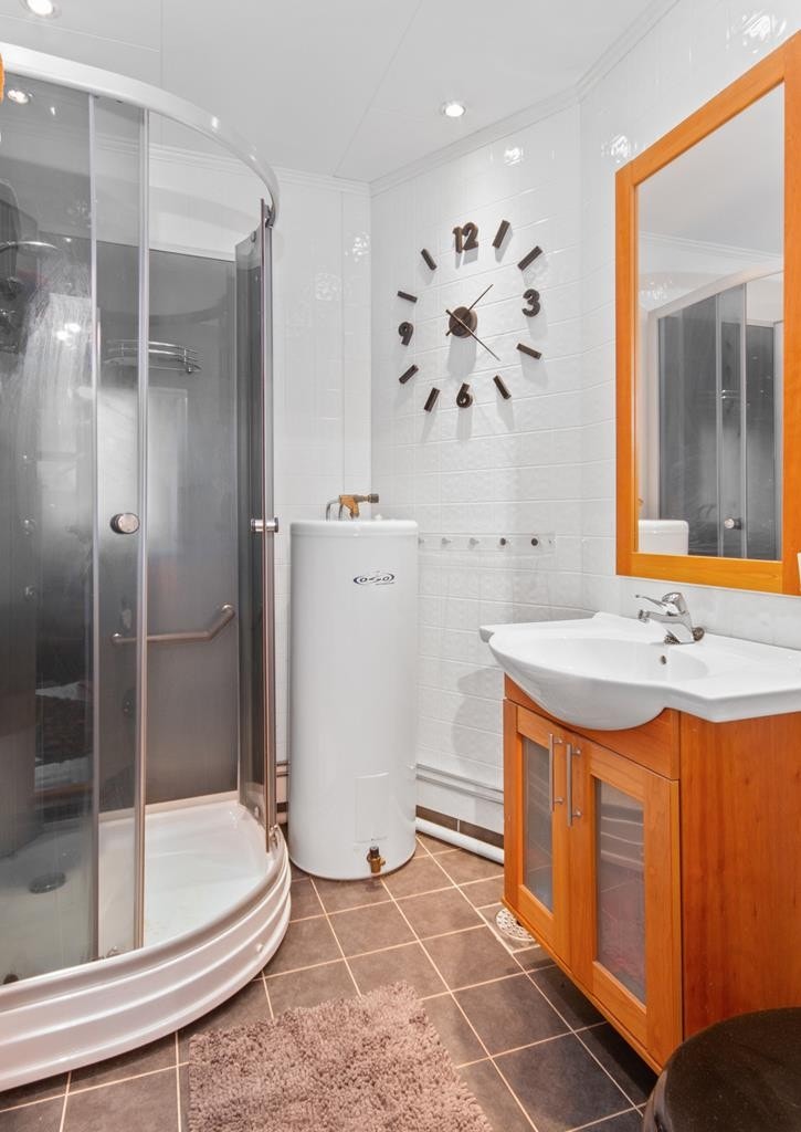 Bad med hvite baderomsplater på vegger, downlights i himling og brune fliser på gulv med behagelig gulvvarme. Galleribilde