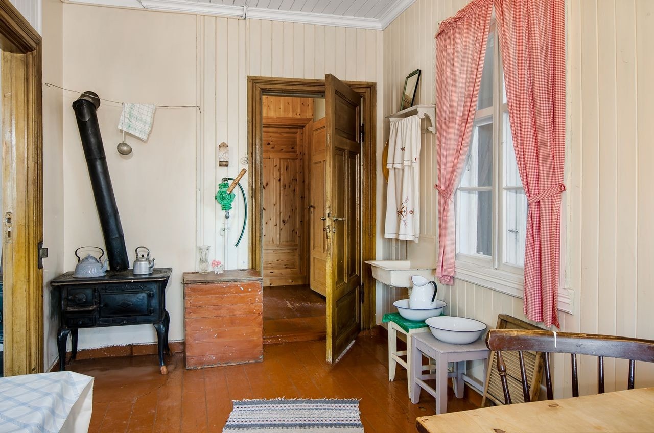 Kjøkkenet har vedkomfyr, vannpumpe og utslagsvask Galleribilde