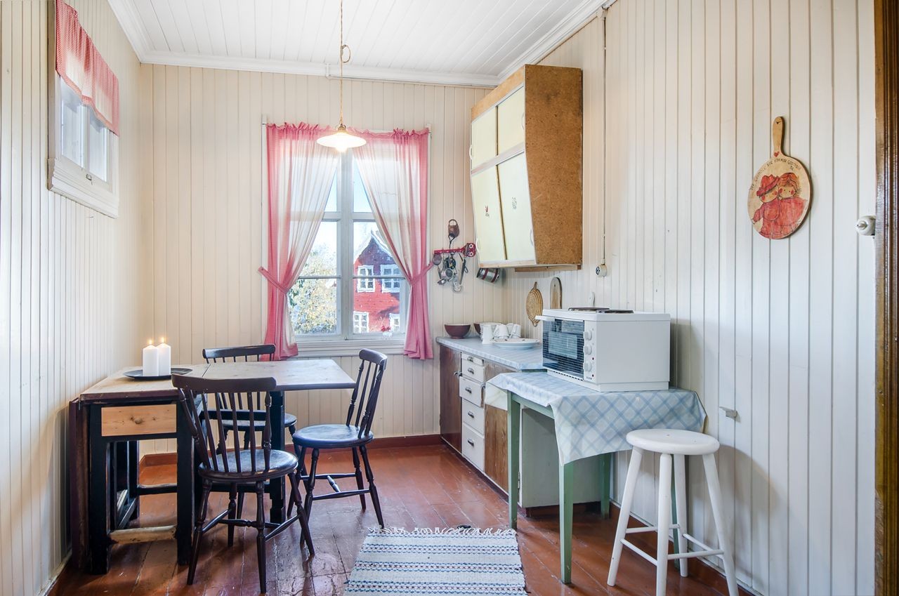 Romslig kjøkken med enkel eldre innredning med over- og underskap Galleribilde