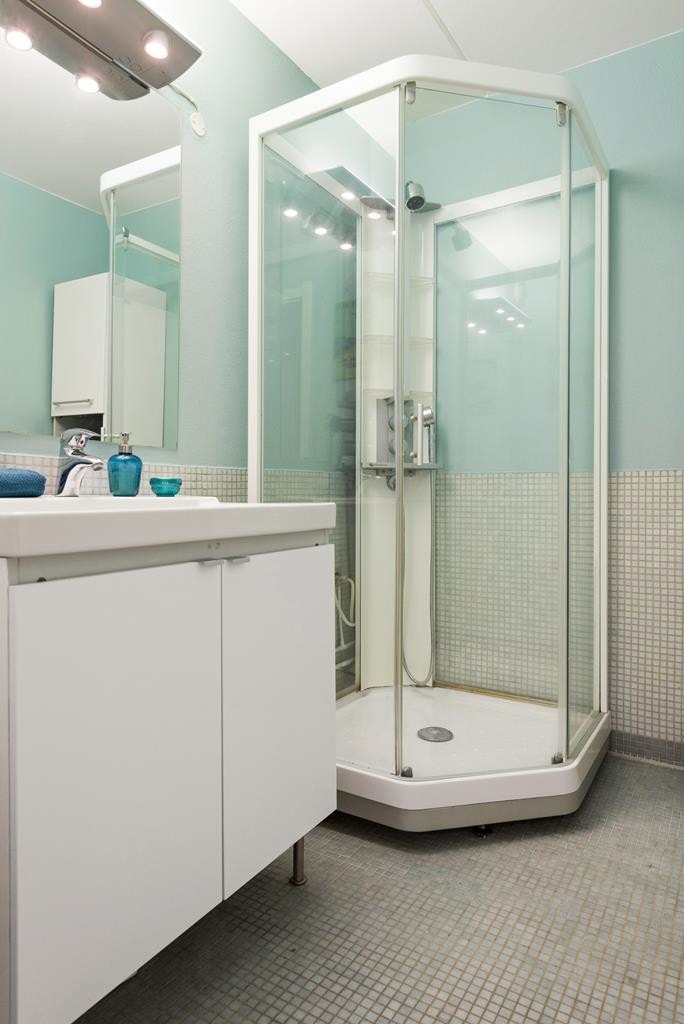 Badet er utstyrt med servant med oppbevaring, speil med lys, praktisk dusjkabinett og høyskap. Galleribilde