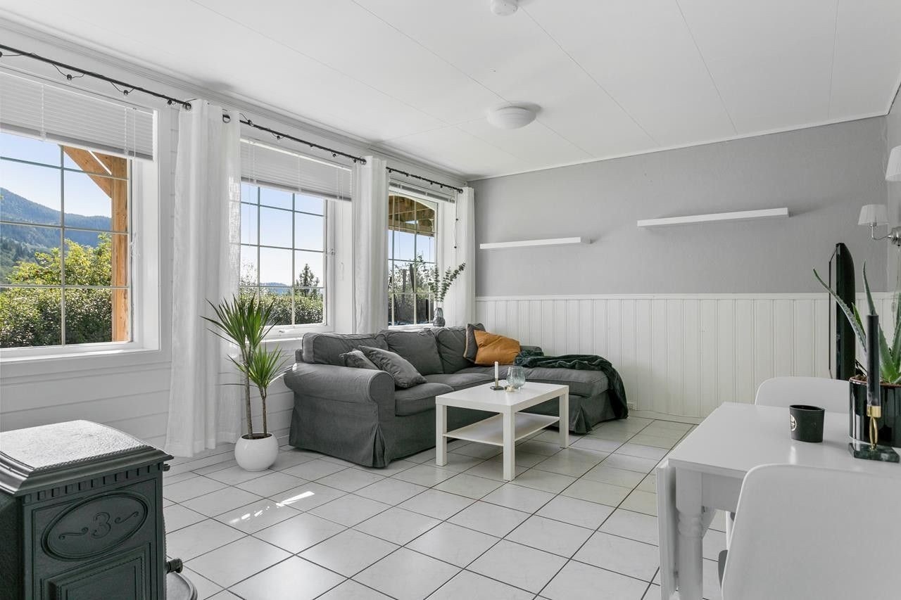 Lys stue med flisgulv, gulvvarme og vedovn. God takhøyde og store vinduer. Galleribilde