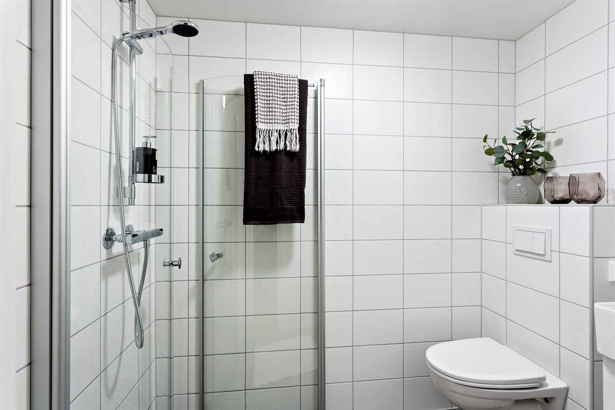 Gjestebadet består av åpen dusjplass med slagdører, heldekkende servant i skapinnredning, speilskap og vegghengt wc. Inngang fra entré. Galleribilde