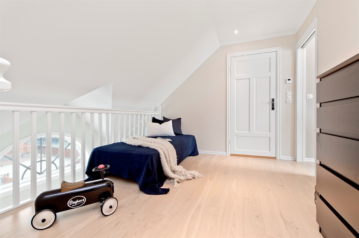 Lys og åpen loftstue med rekkverk ned mot inngangspartiet. Galleribilde