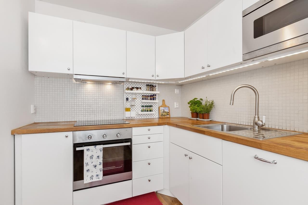 Pen kjøkkeninnredning fra 2013 med hvite slette fronter og heltre benkeplate. Galleribilde