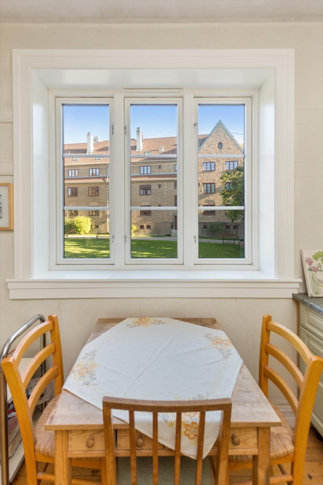 Hyggelig spisebord i kjøkken med utsyn til havebyen Galleribilde