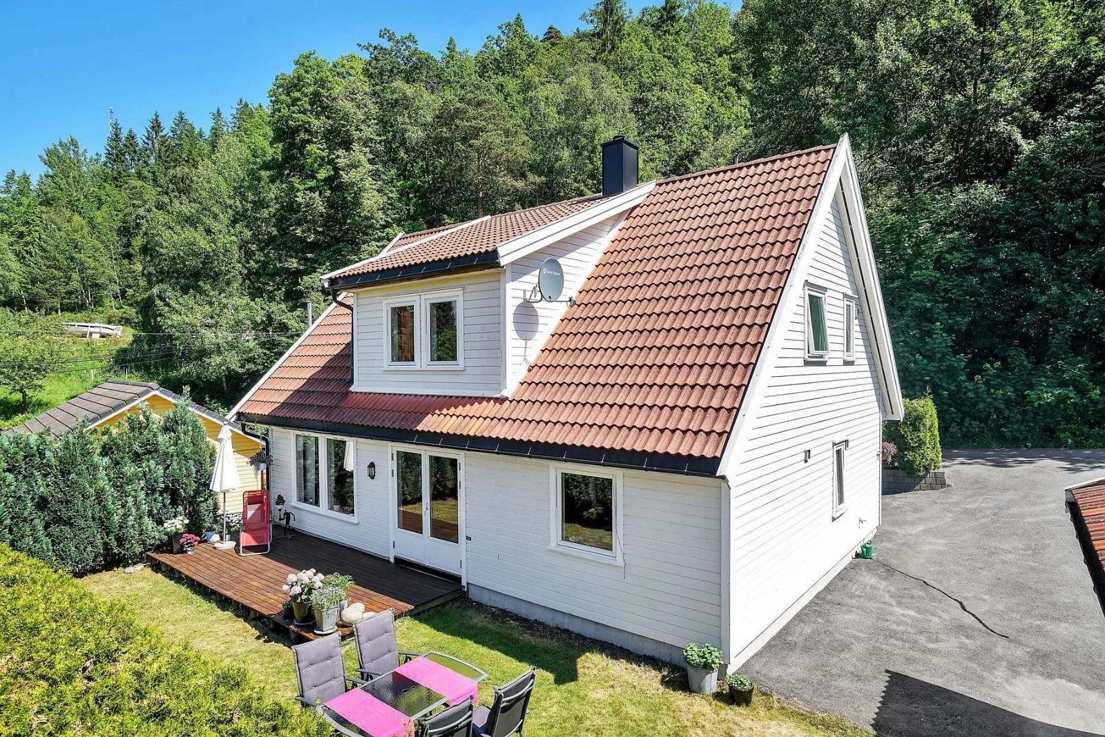 Fasade med solrik terrasse og hage Galleribilde