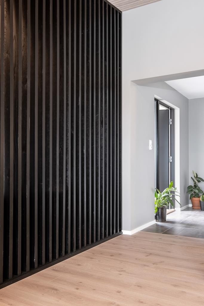 Moderne spilevegg skiller stuen fra gangen. Galleribilde