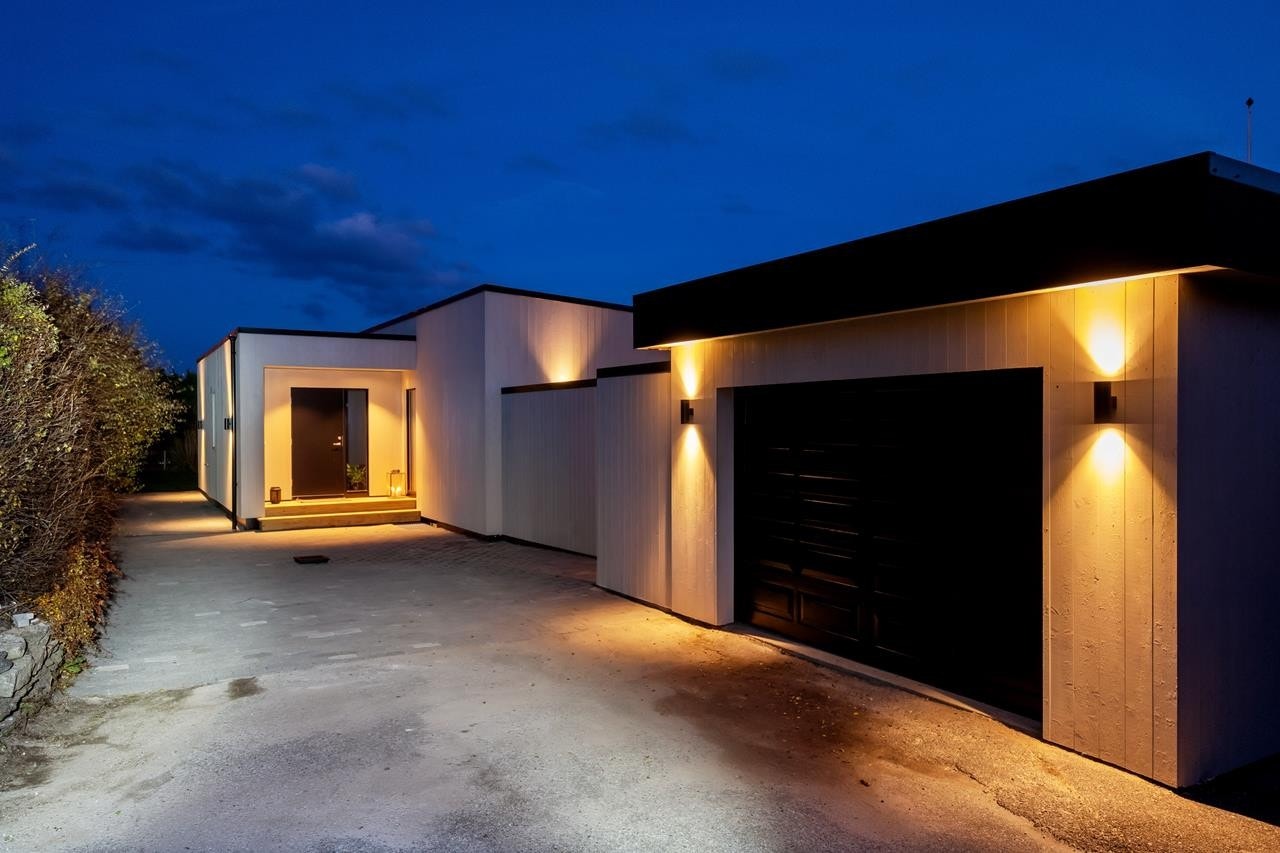 Boligen har en tilhørende garasje samt et gårdsrom med belegningsstein og flere parkeringsplasser. Galleribilde