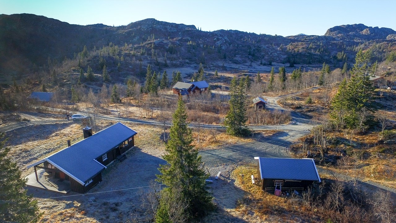Hytta med uthus og stor parkeringsplass Galleribilde
