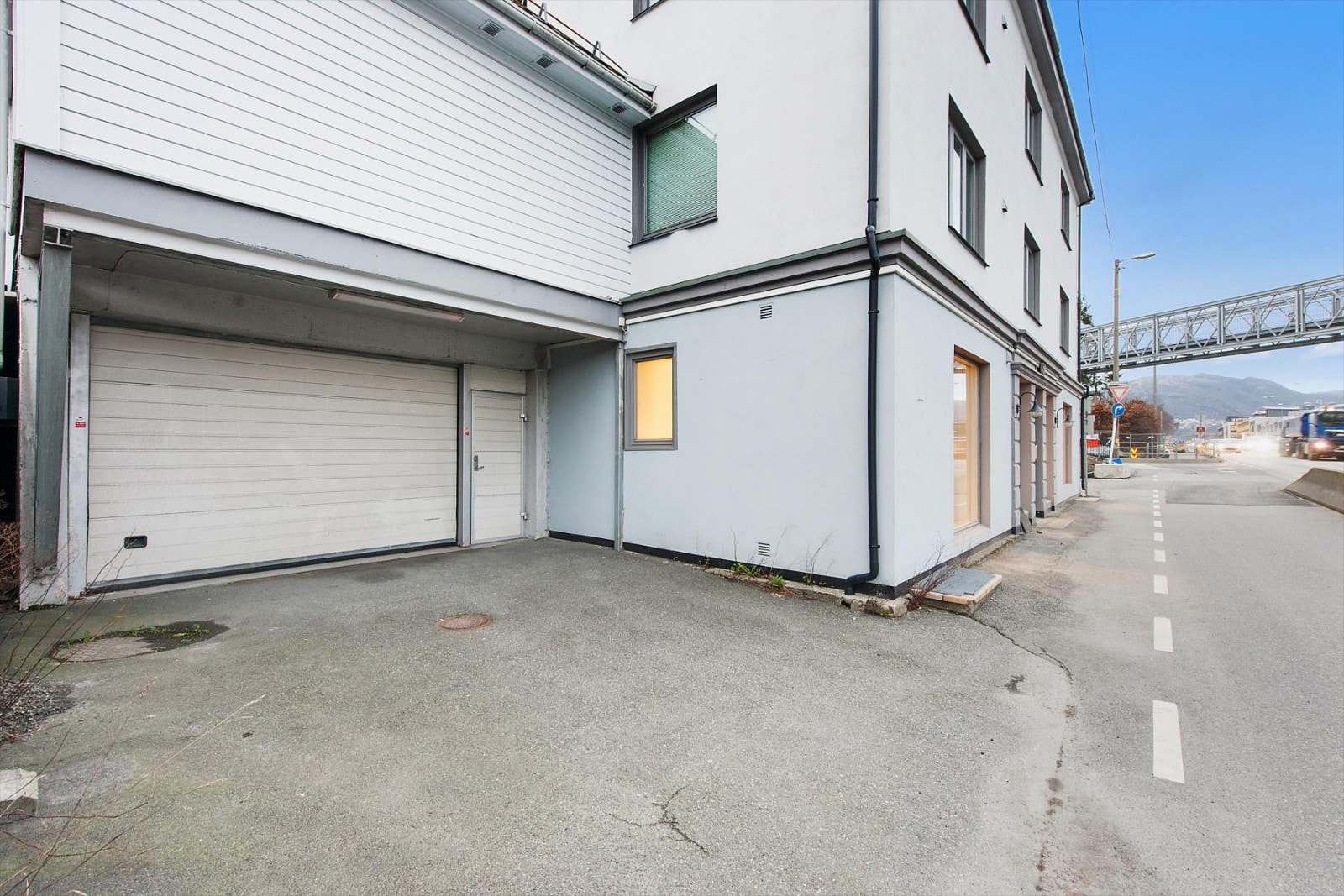 Lager med kjøreport og innvendig adkomst. Dør til mindre felles gang ved siden av kjøreport. Galleribilde