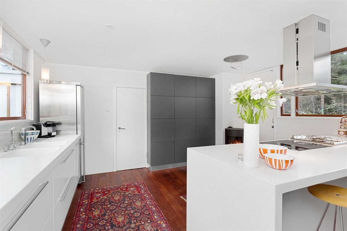 Kjøkkenet er stort og lekkert med stilige detaljer, flere integrerte hvitevarer og en stemningsfull peisovn Galleribilde