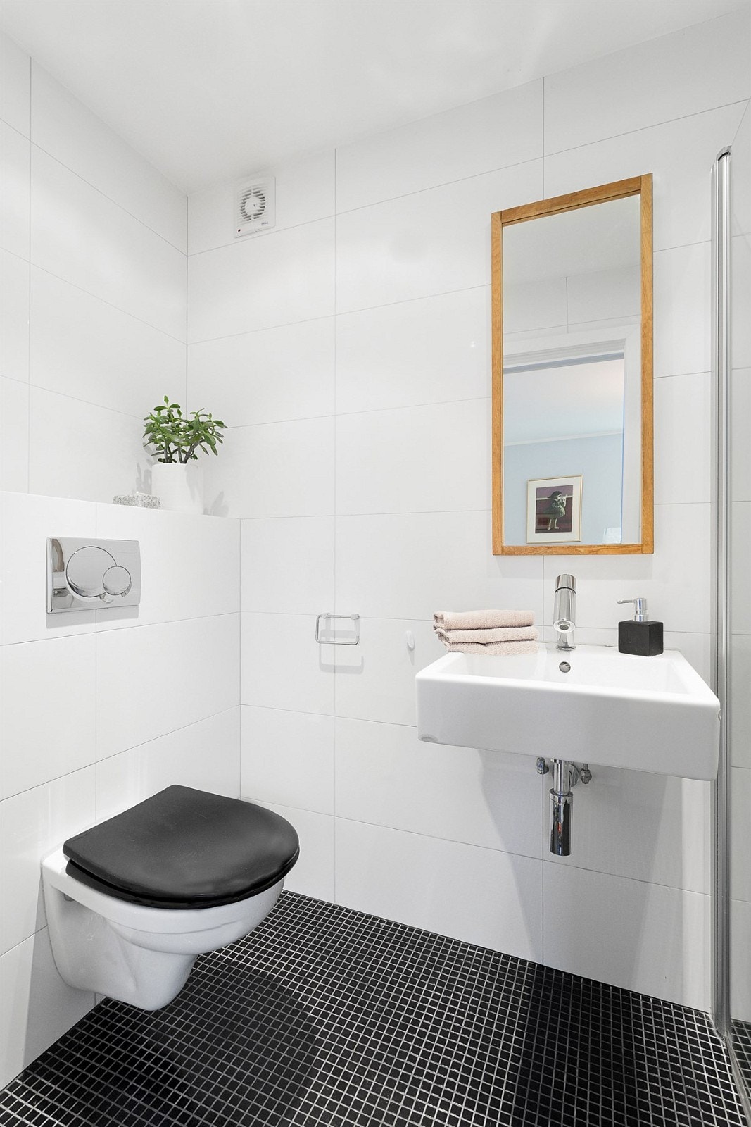 Wc-rommet ble pusset opp i 2015 og har fliser på gulv, veggmontert toalett og servant. Galleribilde