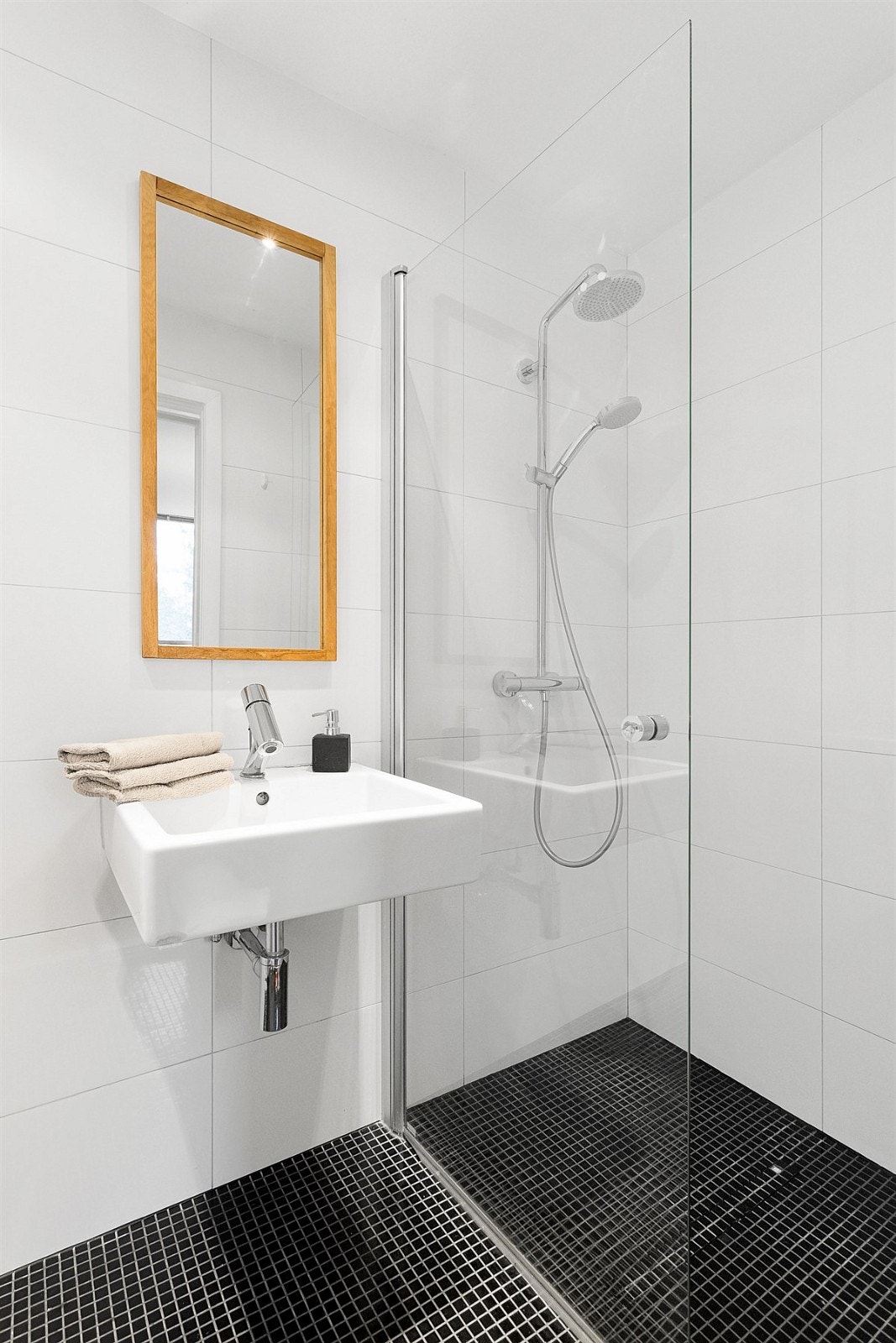 Badet i første etasje er fra 2011 og har mørke mosaikkfliser på gulv og lyse fliser på veggene. Galleribilde