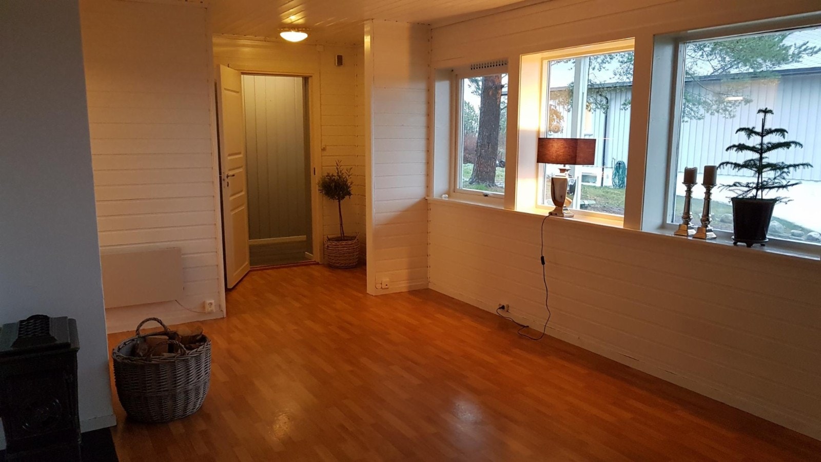 Stuen sett mot vindfanget. Det er fire vinduer og de vender mot syd. Gir mye lys. Parkering til to biler like utenfor huset. Galleribilde