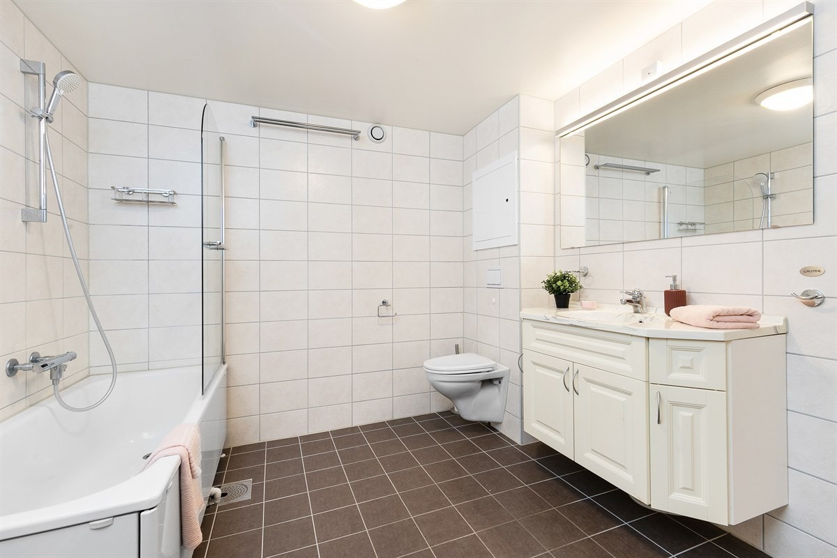 Badet, som er pusset opp av fagfolk i desember 2017 av borettslagets regi, er romslig med mørke gulvfliser og lyse veggfliser. Galleribilde