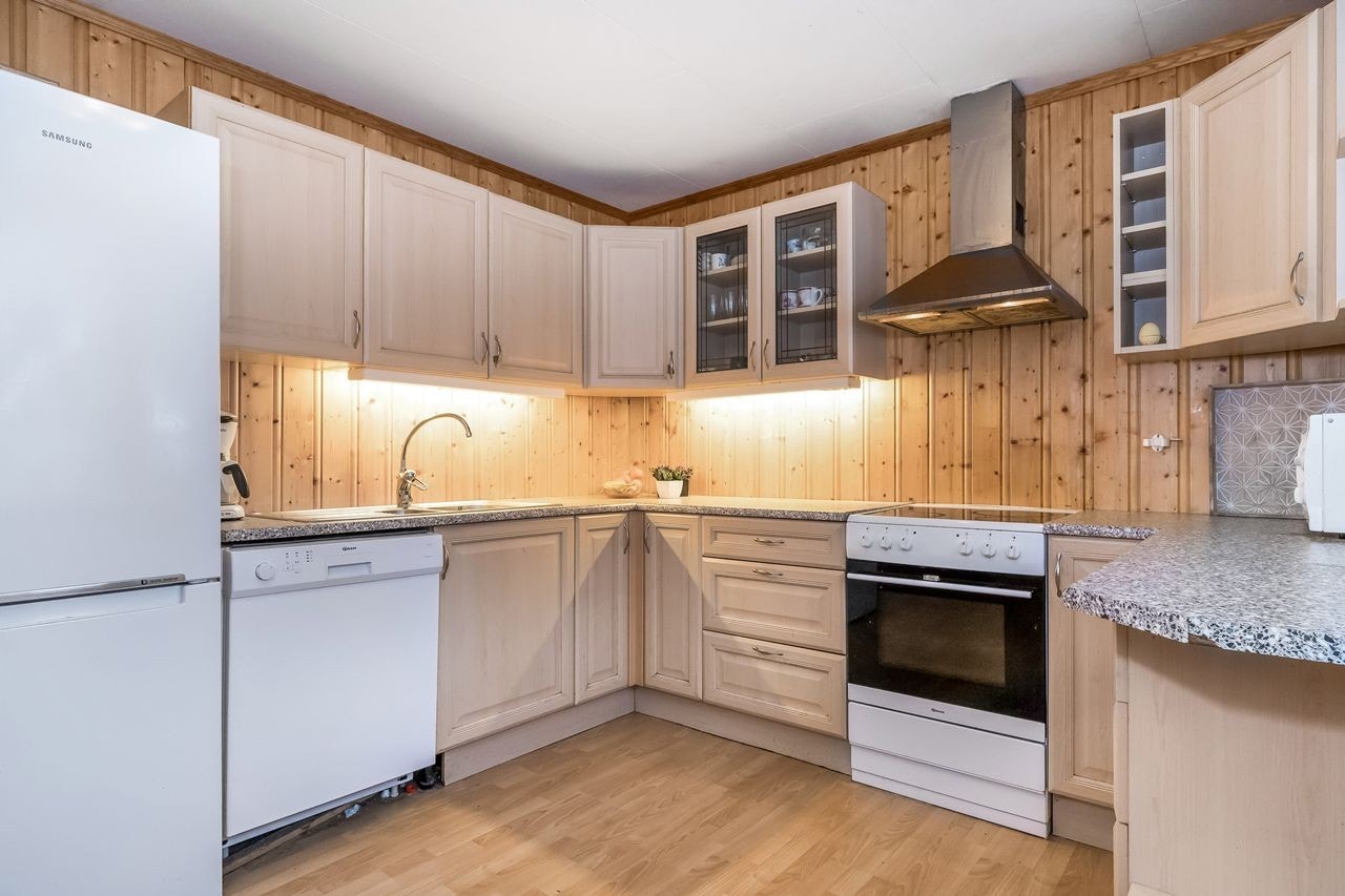 Solid innredning fra byggeåret med lakkerte profilerte fronter og plass for frittstående hvitevarer Galleribilde