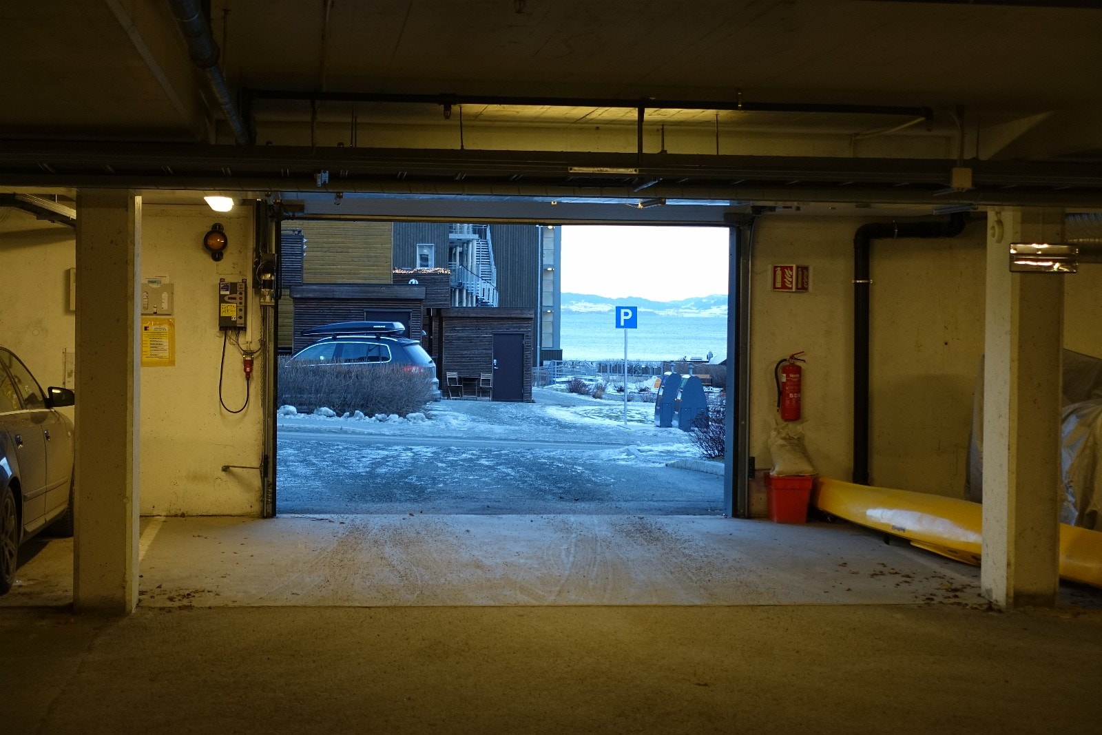 Innkjørsel på bakkeplan til garasjeanlegg med egen p-plass. Galleribilde