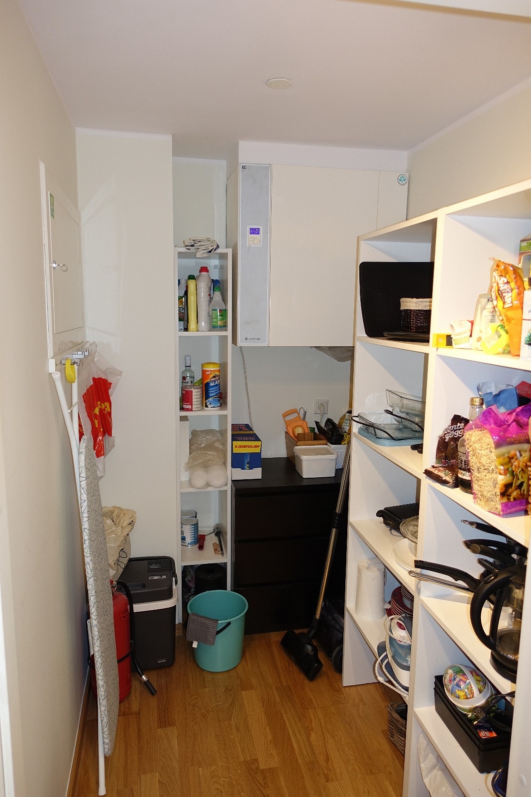 Bod i leiligheten med hyller og stang til å henge klær på. Galleribilde