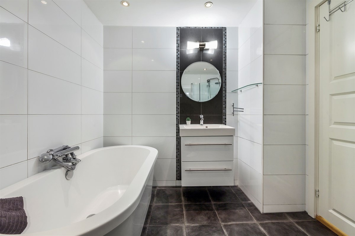 Badet fremstår som moderne og tidsriktig med fliser, varmekabler og downlights i himlingen. Galleribilde