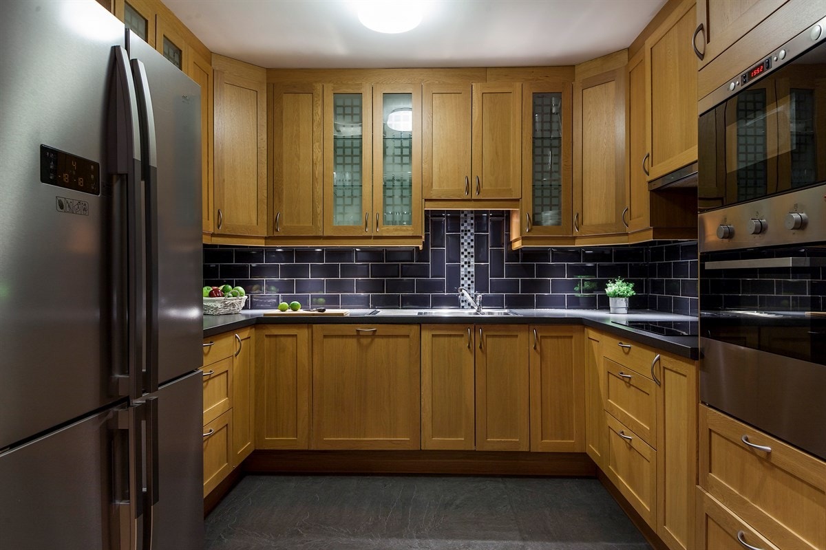 Kjøkkenet har delvis integrerte hvitevarer og profilerte eikefronter. Galleribilde