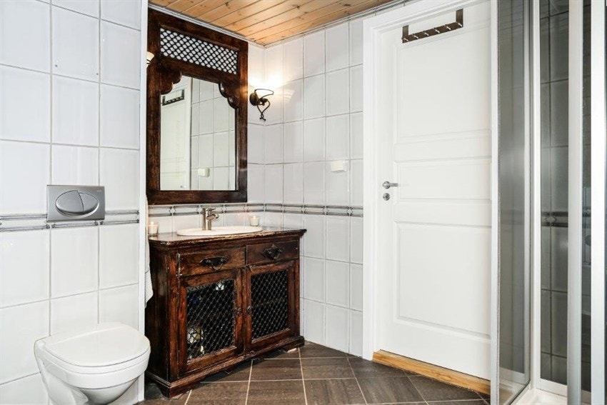 Badet er innredet med vegghengt toalett, servant med underskap Galleribilde