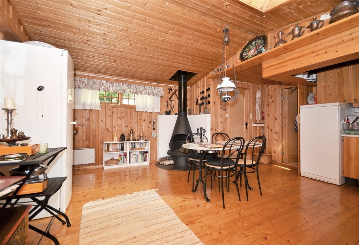 Kjøkken med hvitevarer, spiseplass og peis. Galleribilde
