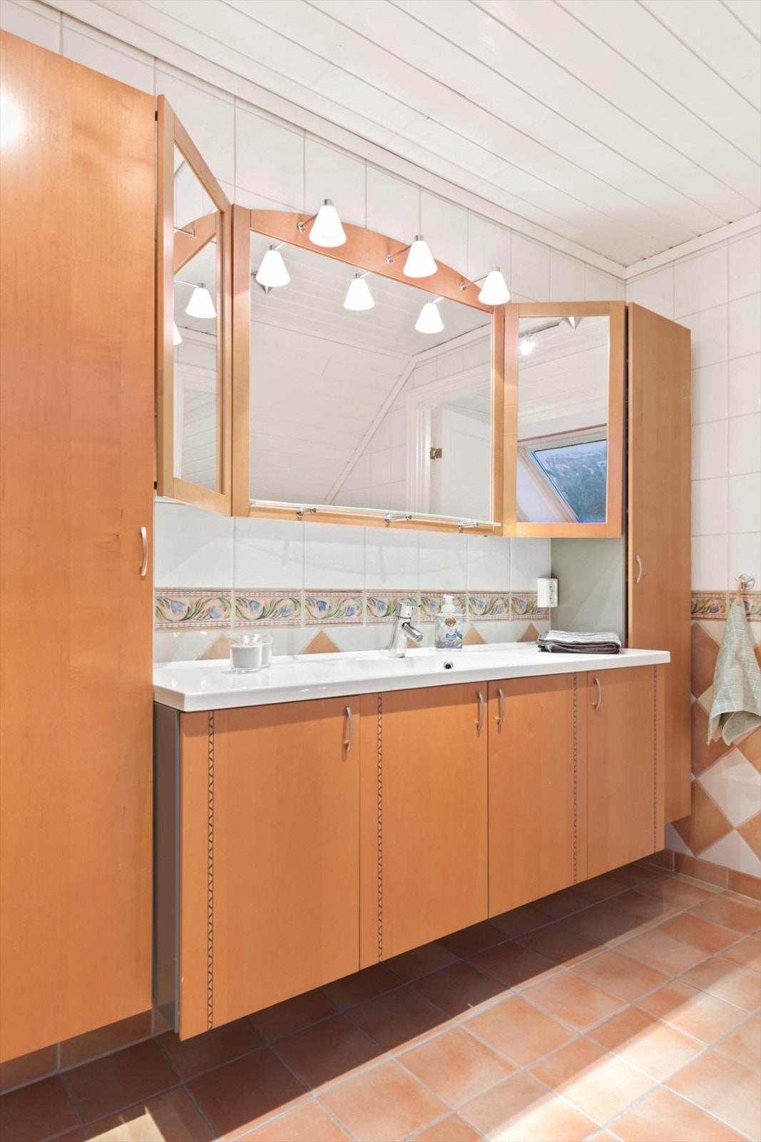 Baderomsinnredning som har godt med lagringsplass. Galleribilde