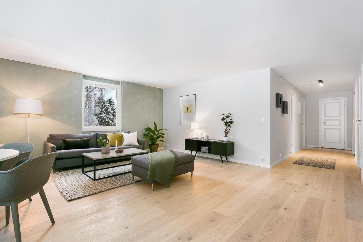Leiligheten har en hyggelig og innbydende stue med lekkert enstavs parkettgulv, lysmalte vegger og store vindusflater Galleribilde