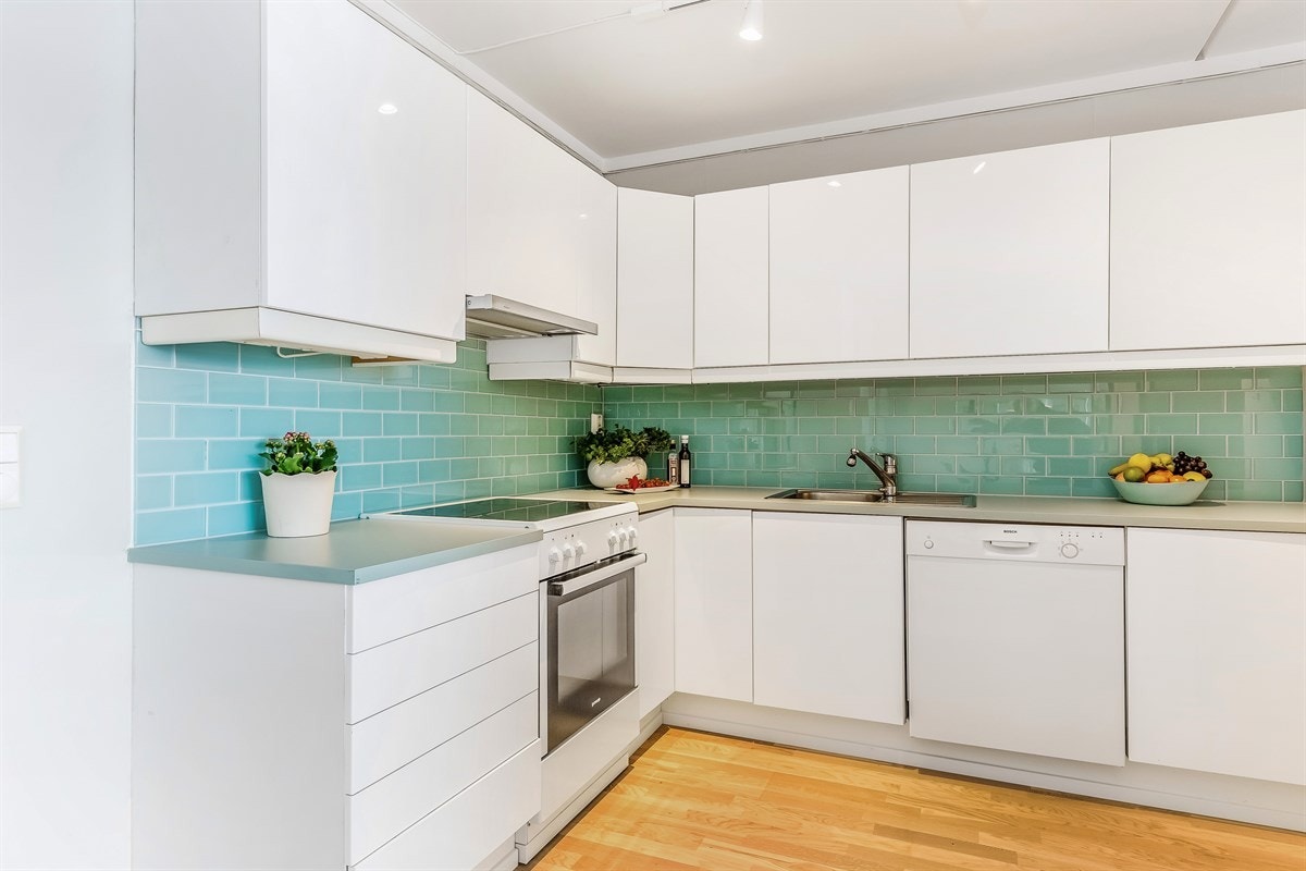 Moderne kjøkkeninnredning med hvite glatte fronter og benkeplate fra 2015. Galleribilde