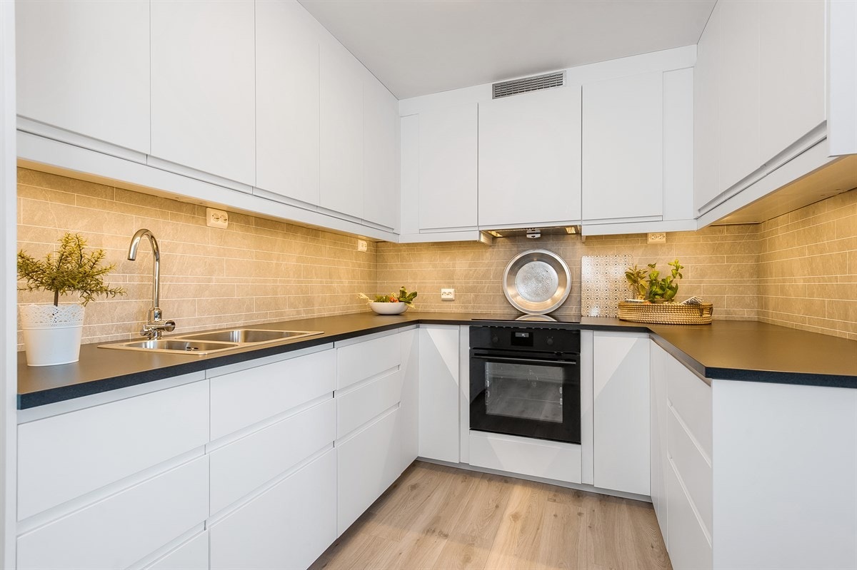 Tidsmessig kjøkkeninnredning fra 2017 med hvite glatte fronter og integrerte hvitevarer. Galleribilde