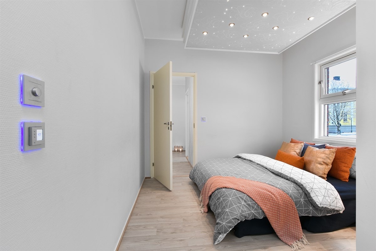 Leiligheten har et romslig soverom med stilig stjernehimling over sengeplass og fin garderobeløsning med speilfronter. Galleribilde