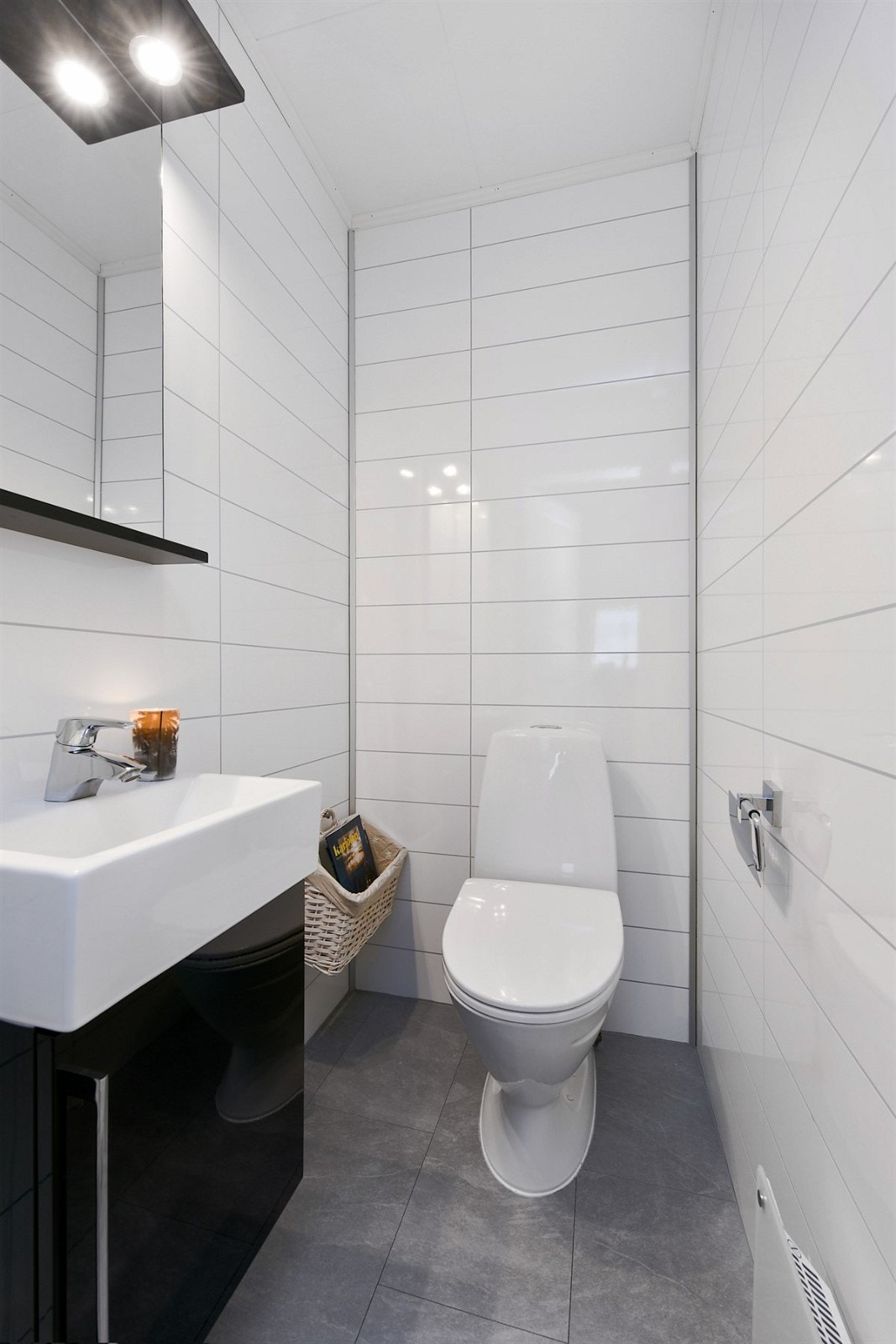 Rommet er utstyrt med dusjkabinett, høyskap og bred, heldekkende servant med skuffeseksjon og speilskap med integrert belysning. Galleribilde