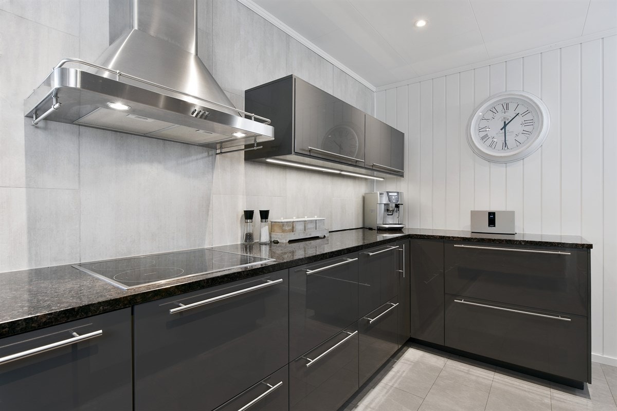 Frontene er i grå høyglans og benkeplaten er i flott granitt med oppvaskkum i stål. Galleribilde