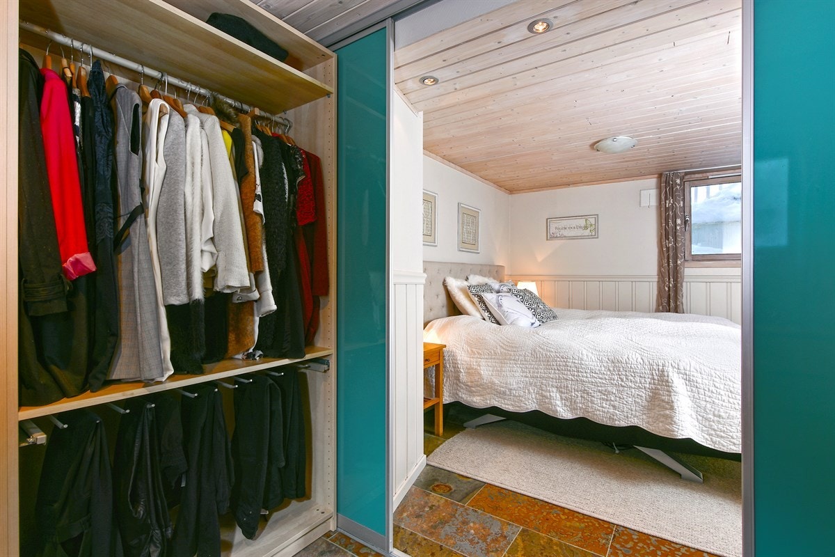 Garderoberommet er rikt innredet med åpne skapseksjoner med skuffer, buksehengere, hyller og sidehengere. Galleribilde