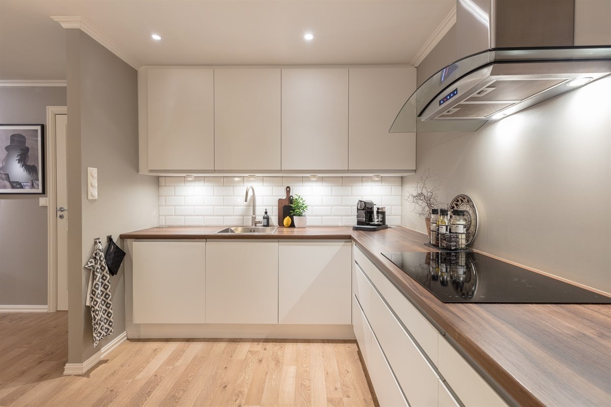 Arbeidsflatene er godt opplyst og det er hvite fliser på veggen. Galleribilde