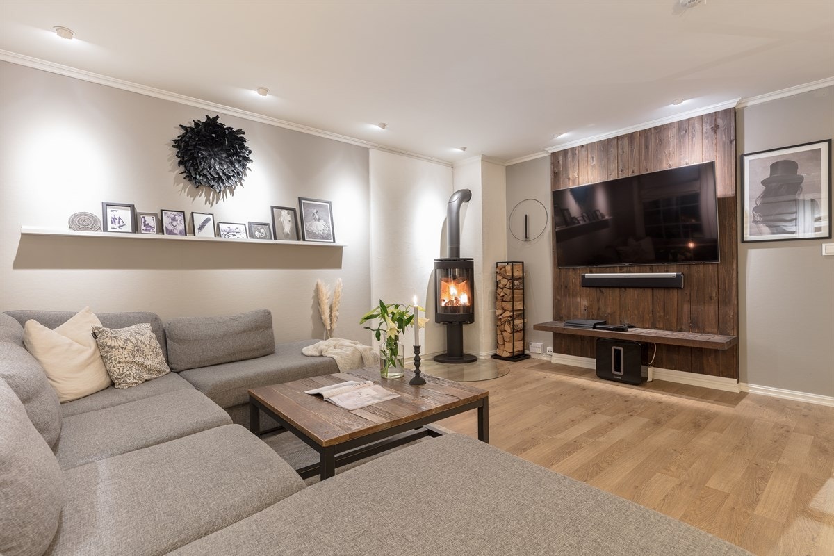 I salongdelen finnes det en mørkbeiset, panelt tv-vegg med veggmontert komponenthylle og feste for tv, samt skjult kabelføring for surroundanlegg. Galleribilde