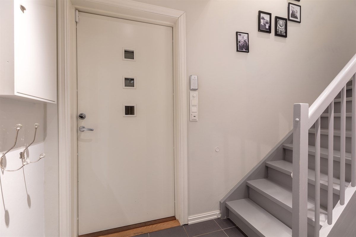 Boligen har et hyggelig inngangsparti med velkomstterrasse og innfelt downlights i takutstikk. Entreen gir et godt førsteinntrykk av boligen og er pent innredet med grå gulvfliser, lysmalte vegger og downlights. Galleribilde