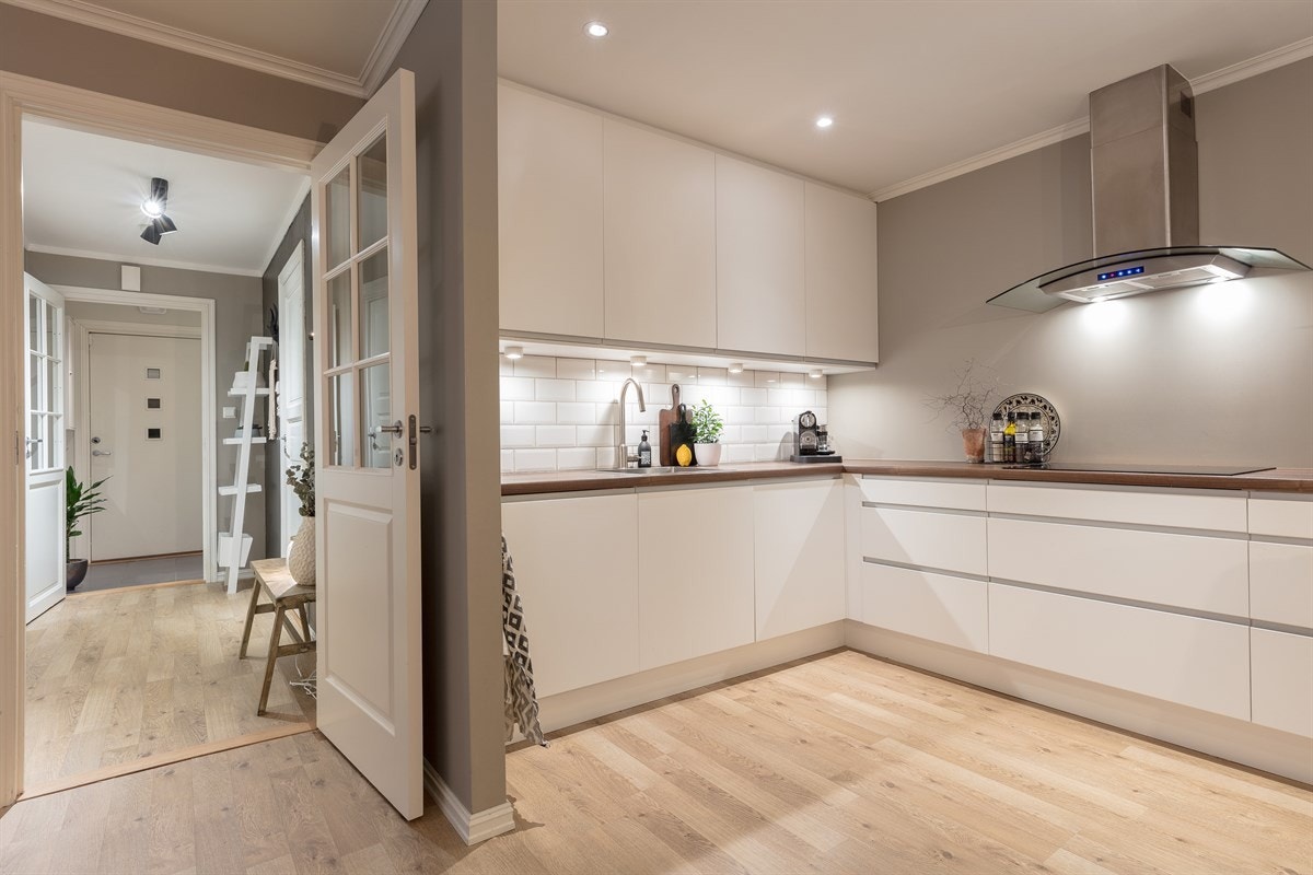 Videre har kjøkkenet integrert stekeovn og mikrobølgeovn i høyskap, nedfelt keramisk topp, integrert kjøl/frys og oppvaskmaskin, samt fritthengende ventilator med hette i glass. Galleribilde