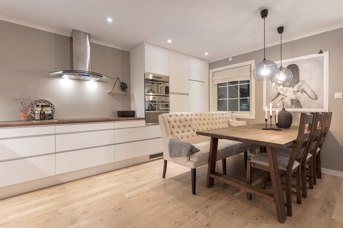 Den takhøye innredningen fra 2012 har hvite, glatte fronter med integrerte håndtak, og laminert benkeplate med enkle oppvaskkum. Galleribilde