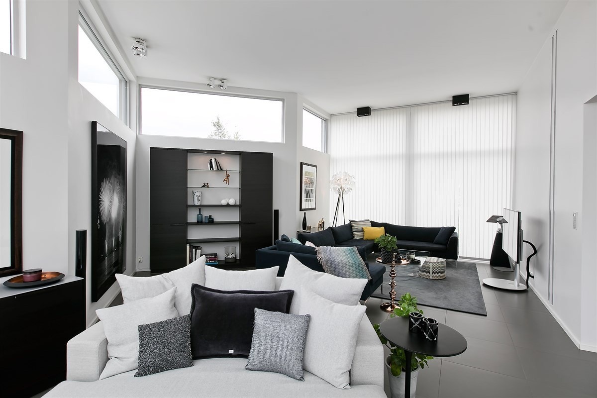 Stuen er lys, luftig og lun med hele 3,5 meter takhøyde og gode møbleringsmuligheter. De store sydvendte vinduene har spesialtilpassede lameller for solavskjerming Galleribilde