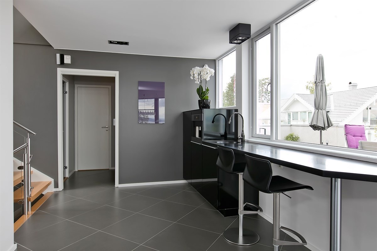 Kjøkkenet har i tillegg egen frokostbar med sitteplasser, og integrert kaffemaskin fra Miele. Innredning fra Poggenpohl Galleribilde