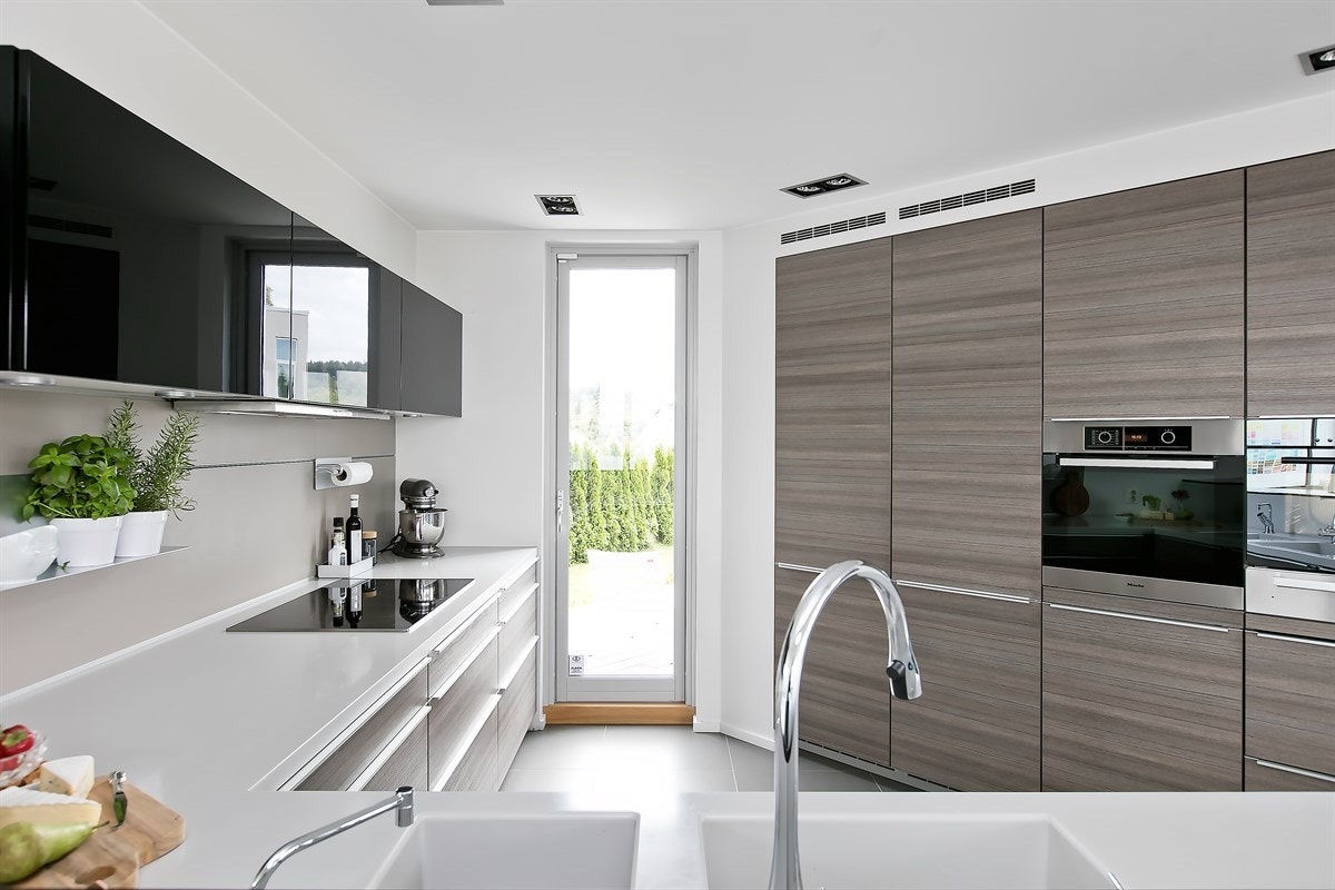 Lekkert og praktisk kjøkken, designet av eier med tanke på funksjonalitet. Kontrollpanel for smarthus-system er på kjøkkenet. Herfra styres hele boligen Galleribilde