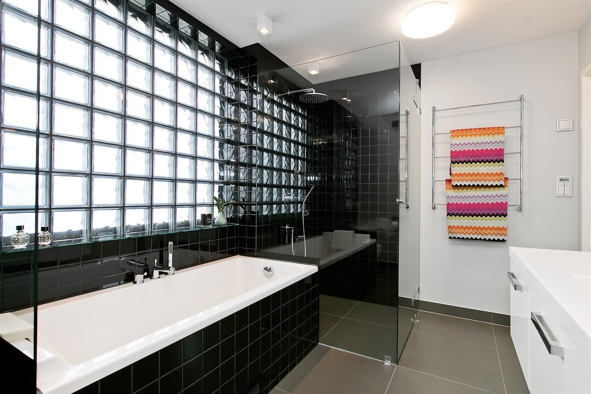 Stort og innbydende master-bad, med tilgang fra hovedsoverom. Ekstra stort dusjhjørne, infliset badekar, dobbeltservant og toalett Galleribilde