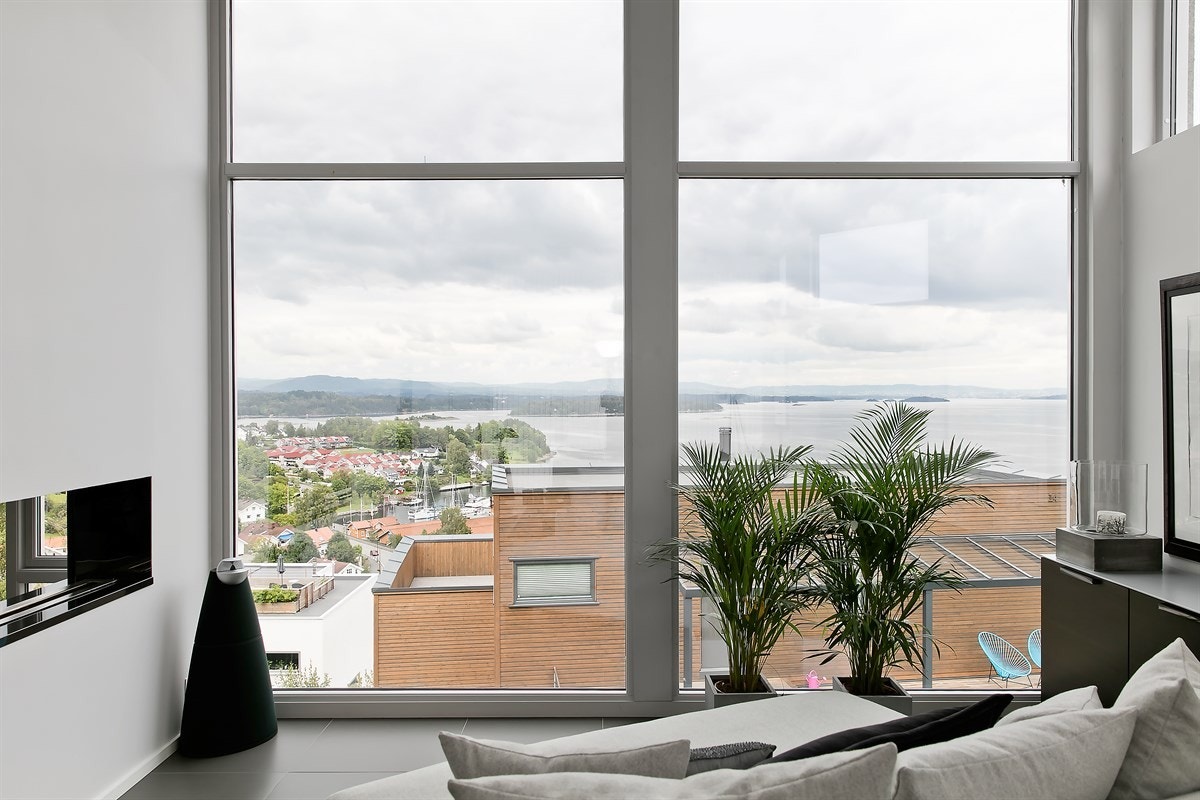 Den fantastiske utsikten kan også nytes fra utsiktspunkt i stuen. Flott biopeis i åpen nisje mellom stuen og spisestuen Galleribilde