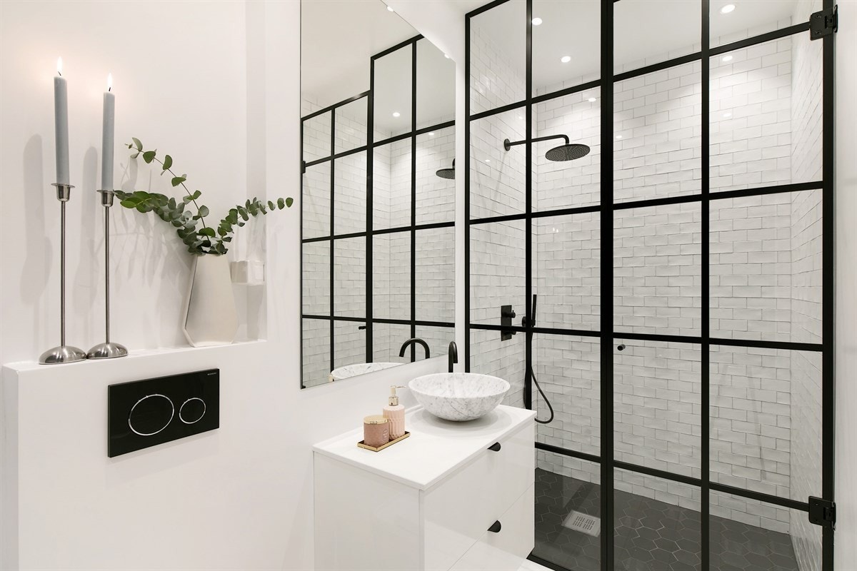 Tidløse hvite fliser og sort hexagon fliser på gulv i dusjsonen. Galleribilde